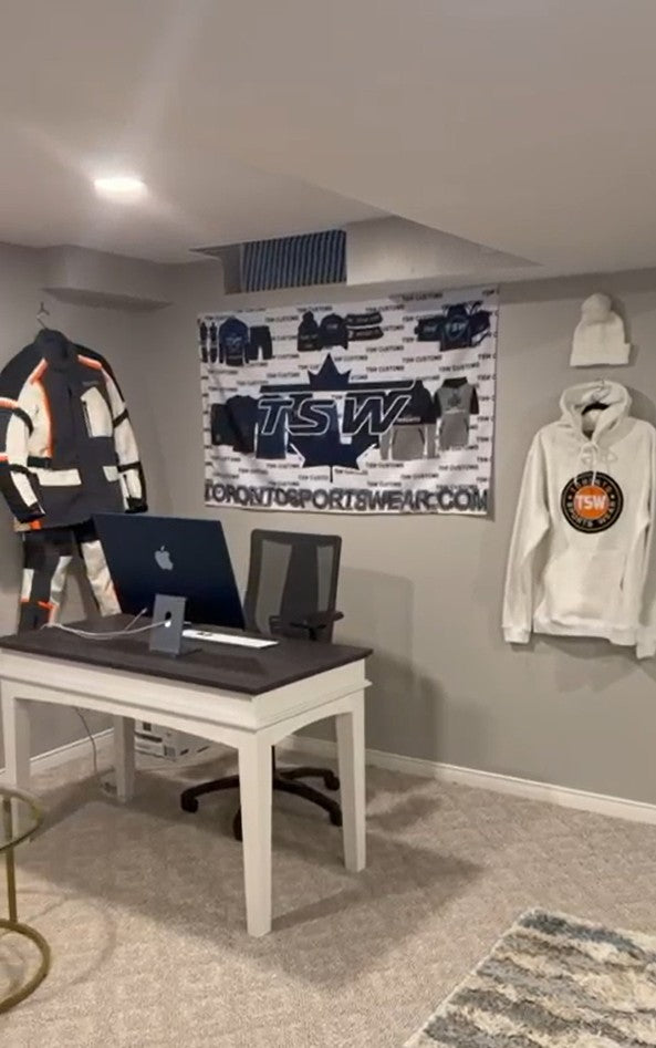Toronto Sportswear design desk with TSW banner, motorcycle jacket and custom hoodie